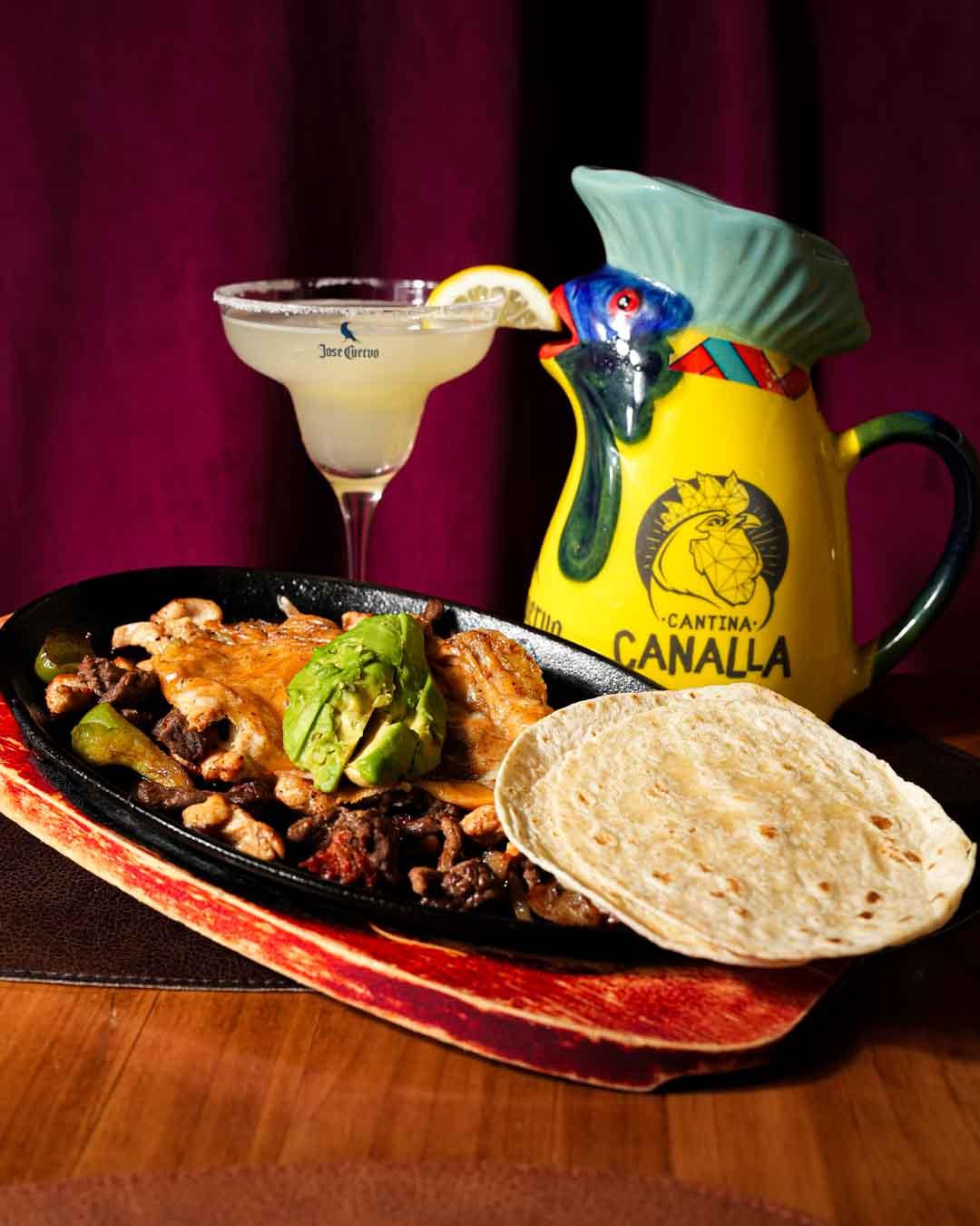 Plato de tacos con margarita de fondo