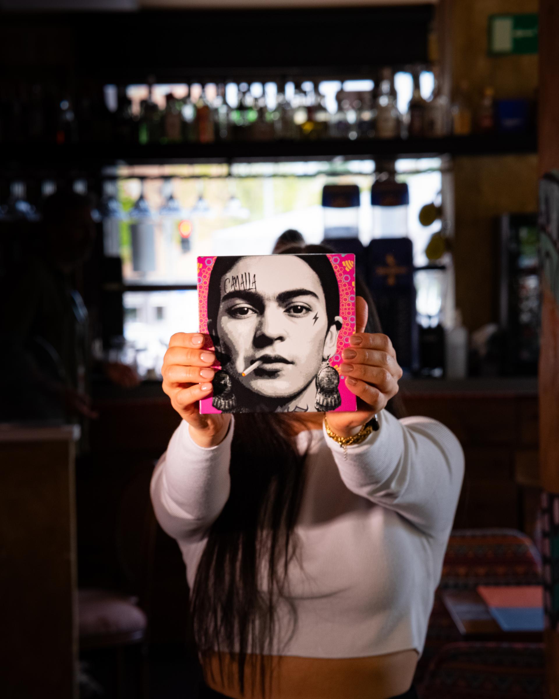 Joven con cuadro de Frida Kalho